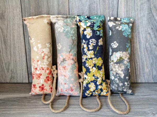 Multiple catnip kicker cat toys made out of a fabric with various prints that look like Japanese cherry blossoms
