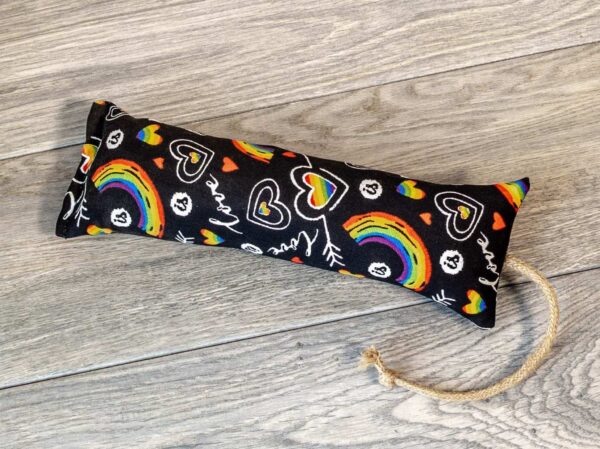 A catnip kicker made from a black fabric that has a pattern of rainbows and the word "love" on it. 
