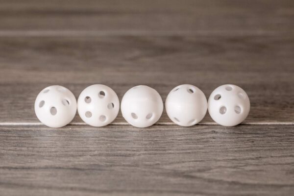 White plastic balls with holes and a rattle inside