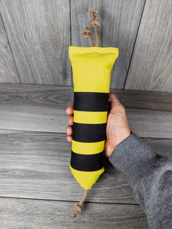 A catnip filled kicker made of a black and yellow fabric that looks like a bumble bee