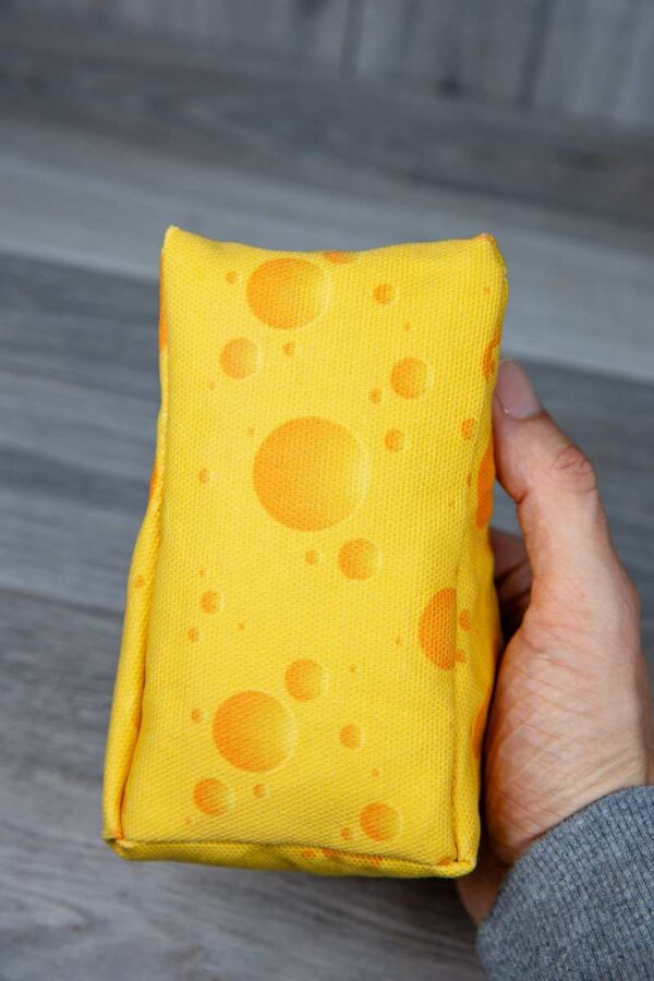 A stuffed toy shaped like a cheese made out of a fabric that looks like cheese