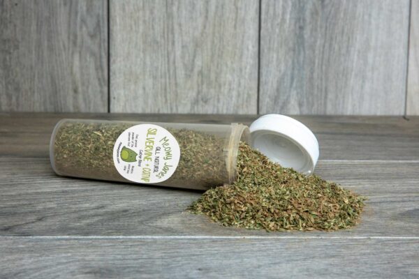 A bottle laying on its side filled with catnip and silvervine. 