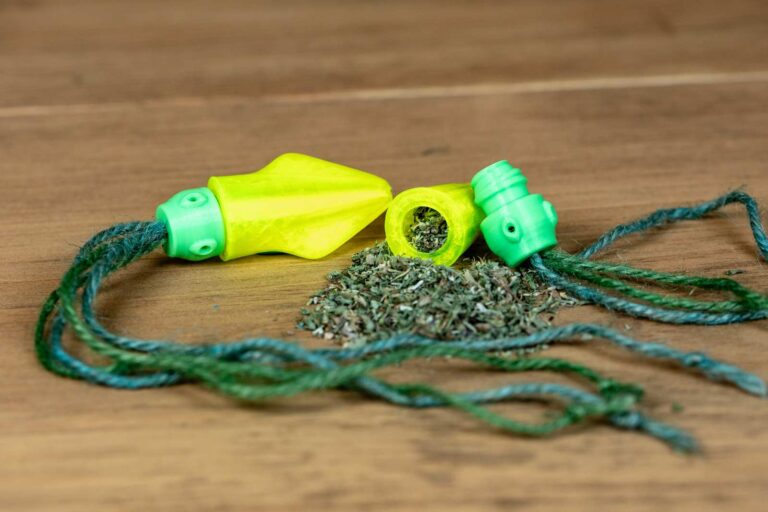 A cat toy that looks like a small squid with yellow body, green head, and jute tentacles. Head is removed from the body to show the catnip inside