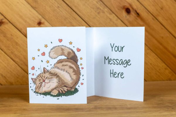 A greeting card with an orange cat surrounded by hearts on the front